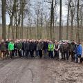 Abgebildet sind viele Bürgerinnen und Bürger sowie Regierungspräsident Heinrich Böckelühr. Alle Personen befinden sich in einem Wald. 