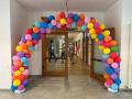 Abgebildet ist der Eingangsbereich einer Schule, der mit bunten Luftballons geschmückt ist. 
