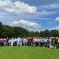 Gruppenbild vor einem Waldstück. Im Hintergrund Windkraftanlagen.