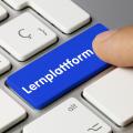 Abgebildet ist eine Tastatur mit weißen Tasten. Die Taste mit der Aufschrift "Lernplattform" ist blau. Eine Person drückt mit einem Finger auf die Taste. 