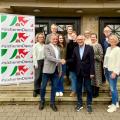 Gruppenbild mit Handschlag vor dem Slogan #sicherimDienst