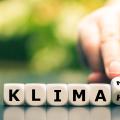 Eine Hand dreht Würfel und ändert den Ausdruck "Klimakiller" in "Klimaneutral".