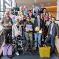 Abgebildet sind mehrere Personen, die für ein Bild posieren. Im Vordergrund ist ein Fahrrad abgestellt.
