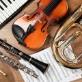 Abgebildet sind mehrere Musikinstrumente und ein Notenblatt.